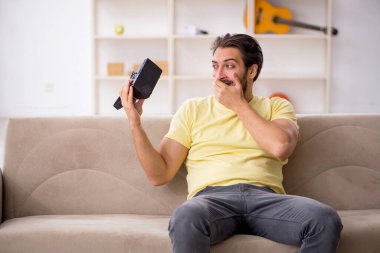 Evde sanal gözlük takan genç bir adam.