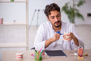 Klinikte çalışan genç erkek dişçi.