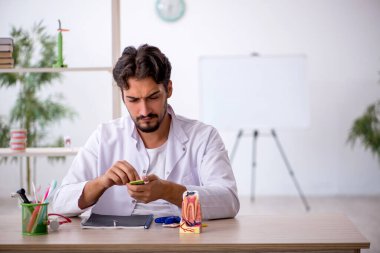 Klinikte çalışan genç erkek dişçi.