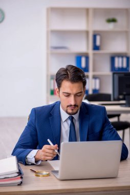 Ofiste çalışan genç bir erkek.