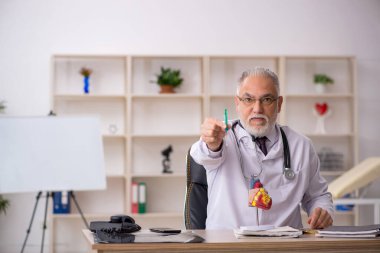Klinikte çalışan yaşlı bir erkek kardiyolog.