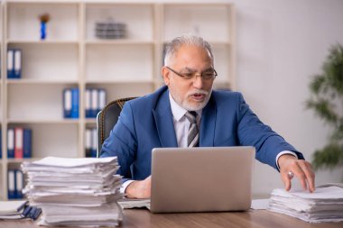 Ofiste çalışan yaşlı bir erkek.