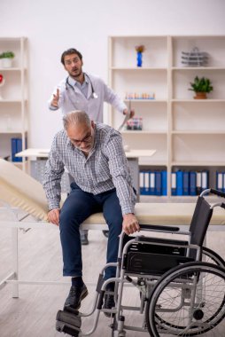 Tekerlekli sandalyedeki yaşlı adam genç erkek doktoru ziyaret ediyor.