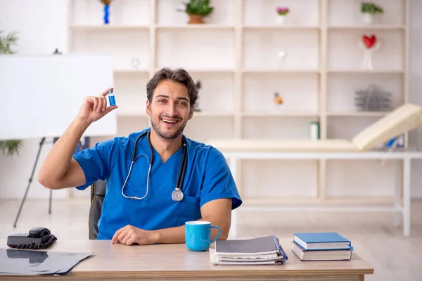 Ung manlig läkare som arbetar på kliniken — Stockfoto