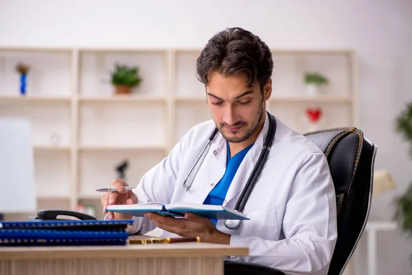 Ung manlig läkare som arbetar på kliniken — Stockfoto