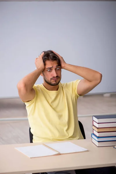 Joven estudiante masculino preparándose para los exámenes en el aula —  Fotos de Stock