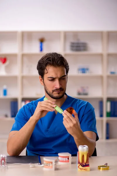 Ung manlig tandläkare som arbetar på kliniken — Stockfoto