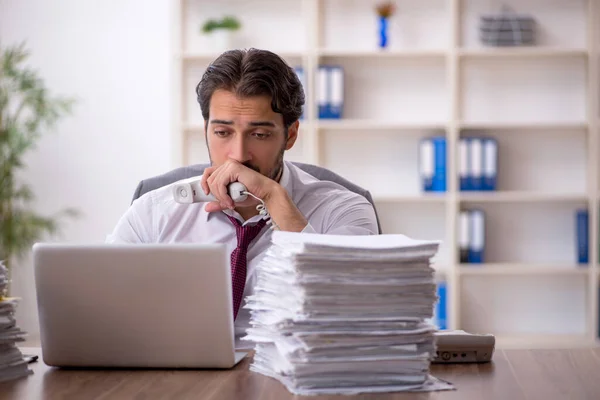 Junge männliche Mitarbeiter und zu viel Arbeit im Büro — Stockfoto