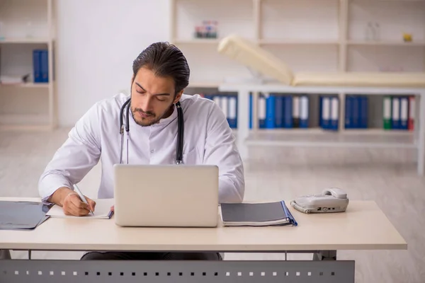 Ung manlig läkare som arbetar på kliniken — Stockfoto