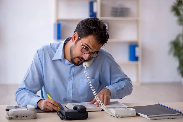 Jovem operador de call center do sexo masculino trabalhando em sua mesa — Fotografia de Stock