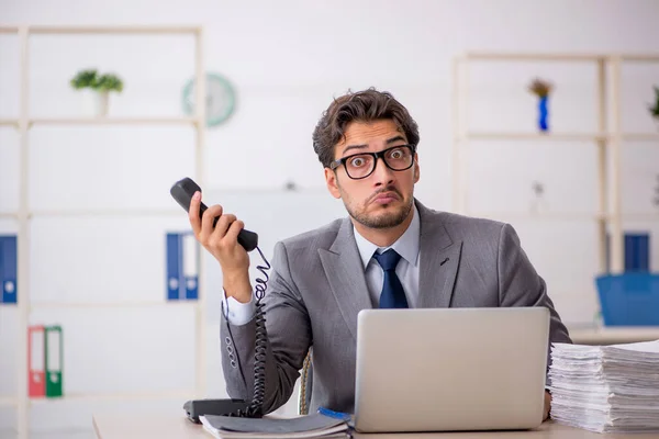 Junge männliche Mitarbeiter sitzen am Arbeitsplatz — Stockfoto