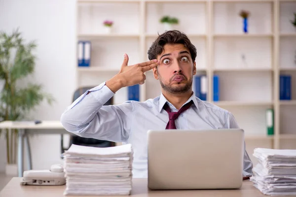 Junge männliche Mitarbeiter und zu viel Arbeit im Büro — Stockfoto