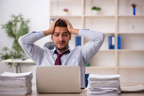 Jeune employé masculin et trop de travail au bureau — Photo