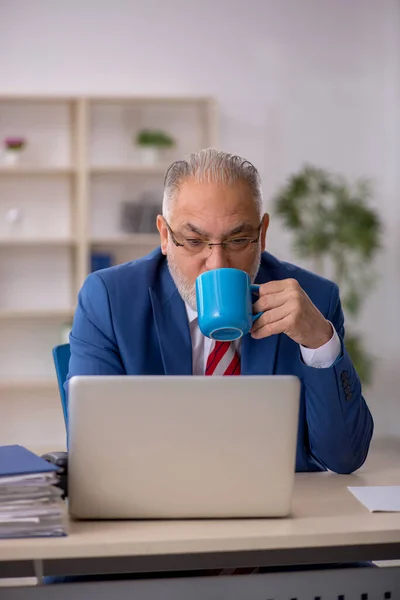 Alte männliche Angestellte trinkt Kaffee in der Pause — Stockfoto