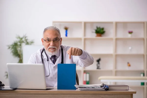 Klinikte çalışan yaşlı erkek doktor. — Stok fotoğraf