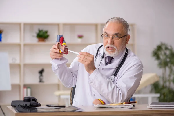 Viejo médico cardiólogo que trabaja en la clínica —  Fotos de Stock