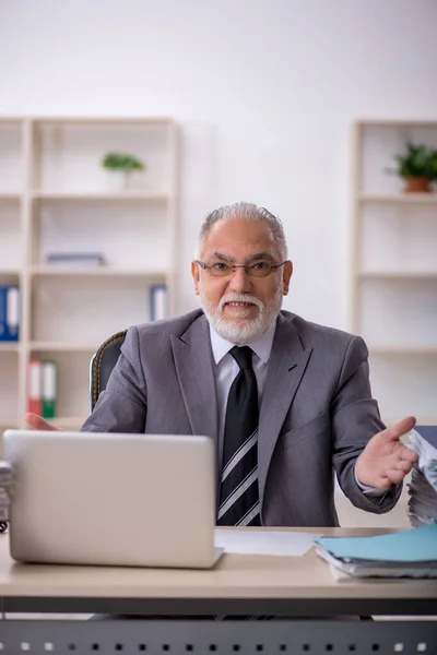 Παλιός υπάλληλος και πολλή δουλειά στο γραφείο. — Φωτογραφία Αρχείου