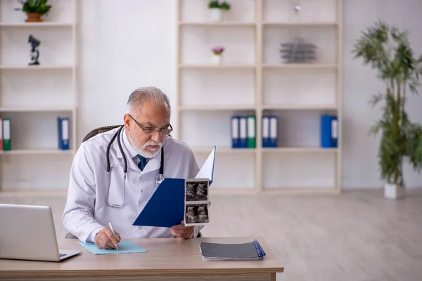 Klinikte çalışan yaşlı bir erkek radyolog. — Stok fotoğraf