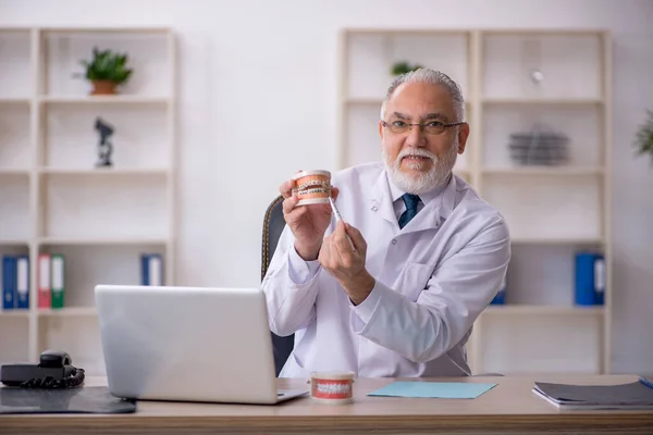 Velho médico dentista trabalhando na clínica — Fotografia de Stock