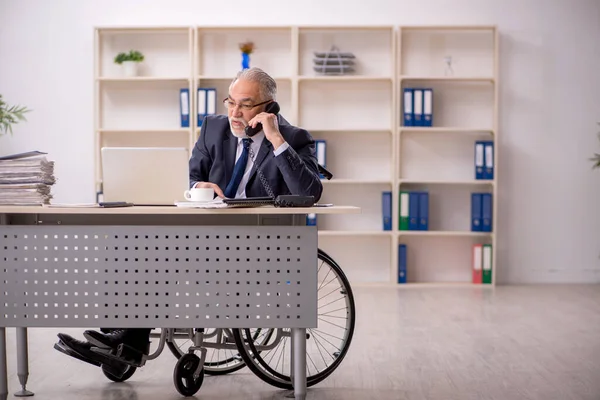 A munkahelyen ülő kerekesszékes idős férfi alkalmazott — Stock Fotó