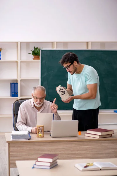 Gammel mannlig lærer og ung mannlig student i godtgjøringskonsept – stockfoto