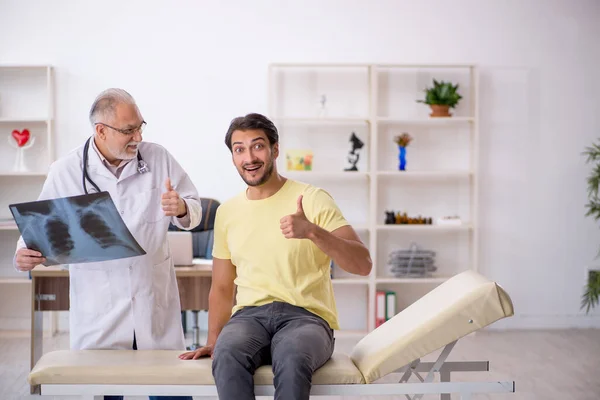 Ung manlig läkare besöker gammal manlig läkare radiolog — Stockfoto