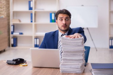 Ofisteki aşırı işten memnun olmayan genç bir erkek işçi.