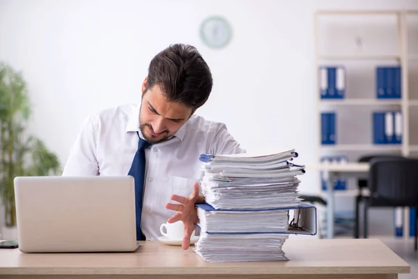 Jovem funcionário masculino infeliz com excesso de trabalho no escritório — Fotografia de Stock