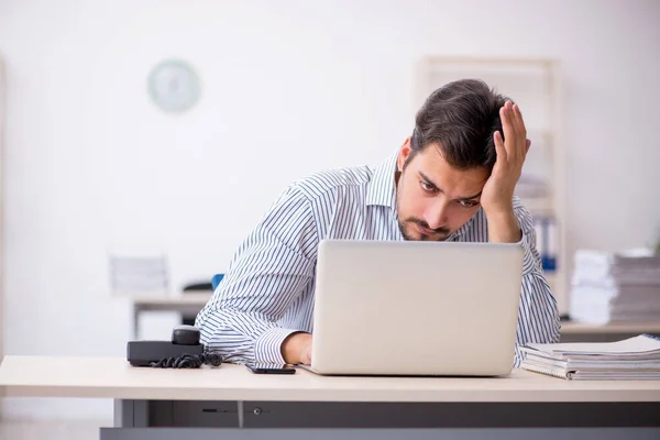 Junge männliche Mitarbeiter und zu viel Arbeit im Büro — Stockfoto