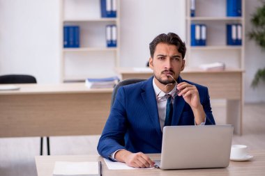 Ofiste çalışan genç bir erkek.