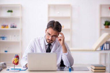 Klinikte çalışan genç bir erkek kardiyolog.