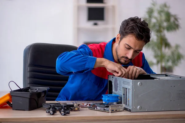 Молодой ремонтник-мужчина ремонтирует компьютер — стоковое фото