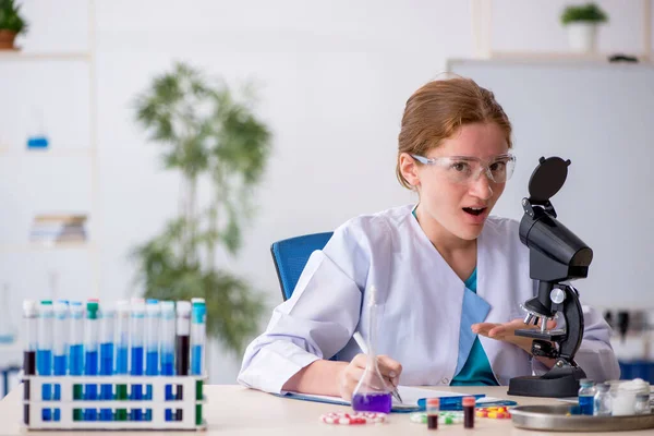 Joven química femenina en concepto de síntesis de fármacos — Foto de Stock