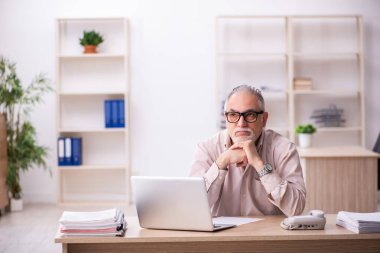 İş yerinde çalışan yaşlı bir erkek işçi.