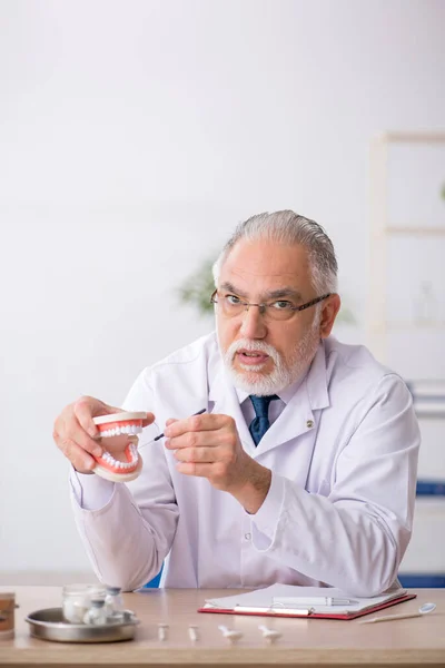 Gammal manlig läkare tandläkare som arbetar på kliniken — Stockfoto