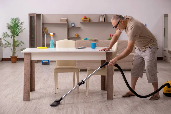 Viejo haciendo tareas domésticas en casa — Foto de Stock