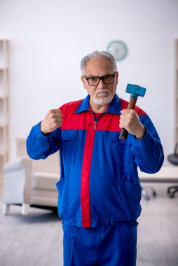 Atölyede çalışan yaşlı bir tamirci.