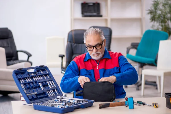 Старый мужчина-ремонтник работает в мастерской — стоковое фото