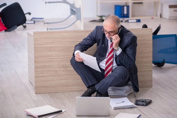 Old male employee working overtime in the office — Stock Photo, Image