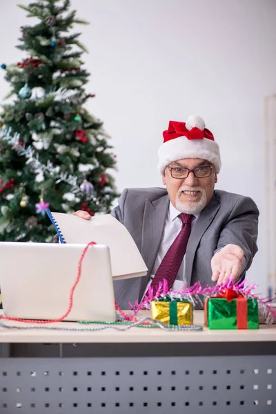 Věk muž zaměstnanec slaví Vánoce na pracovišti — Stock fotografie