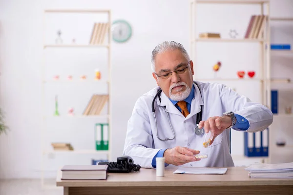 Klinikte çalışan yaşlı erkek doktor. — Stok fotoğraf