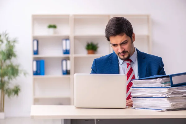 Jovem funcionário masculino infeliz com excesso de trabalho no escritório — Fotografia de Stock