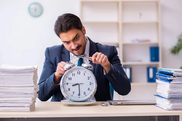 目覚まし時計を食べる若いビジネスマンの従業員 — ストック写真