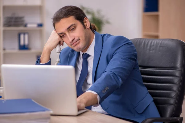 Jonge mannelijke werknemer op kantoor — Stockfoto