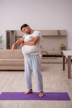 Genç adam evde spor yapıyor.