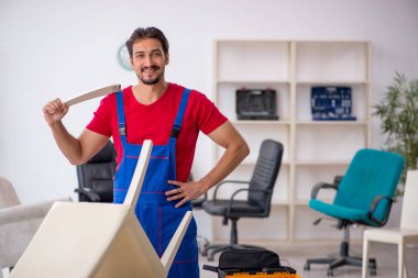 Genç erkek marangoz atölyede çalışıyor.