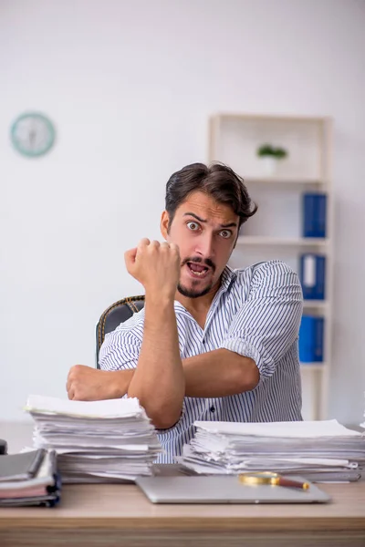 Giovane dipendente maschio infelice con un lavoro eccessivo in ufficio — Foto Stock