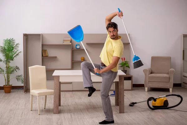 Giovane uomo che fa i lavori domestici a casa — Foto Stock