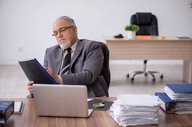 Ofiste çalışan yaşlı bir erkek.