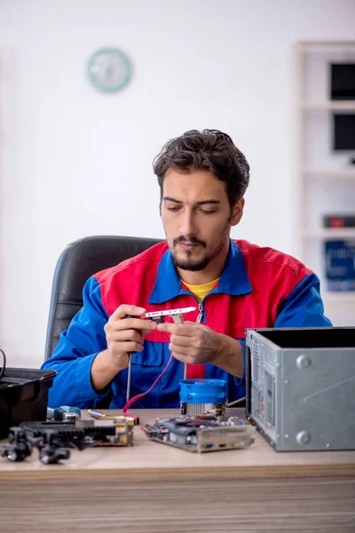 Jovem reparador do sexo masculino reparando computador — Fotografia de Stock